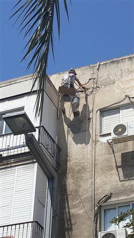 צוות אלדרור בעבודת שיפוץ חזית בניין