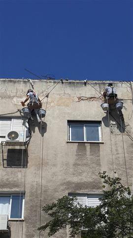 צוות אלדרור על חזית בניין — ריסוס ואיטום